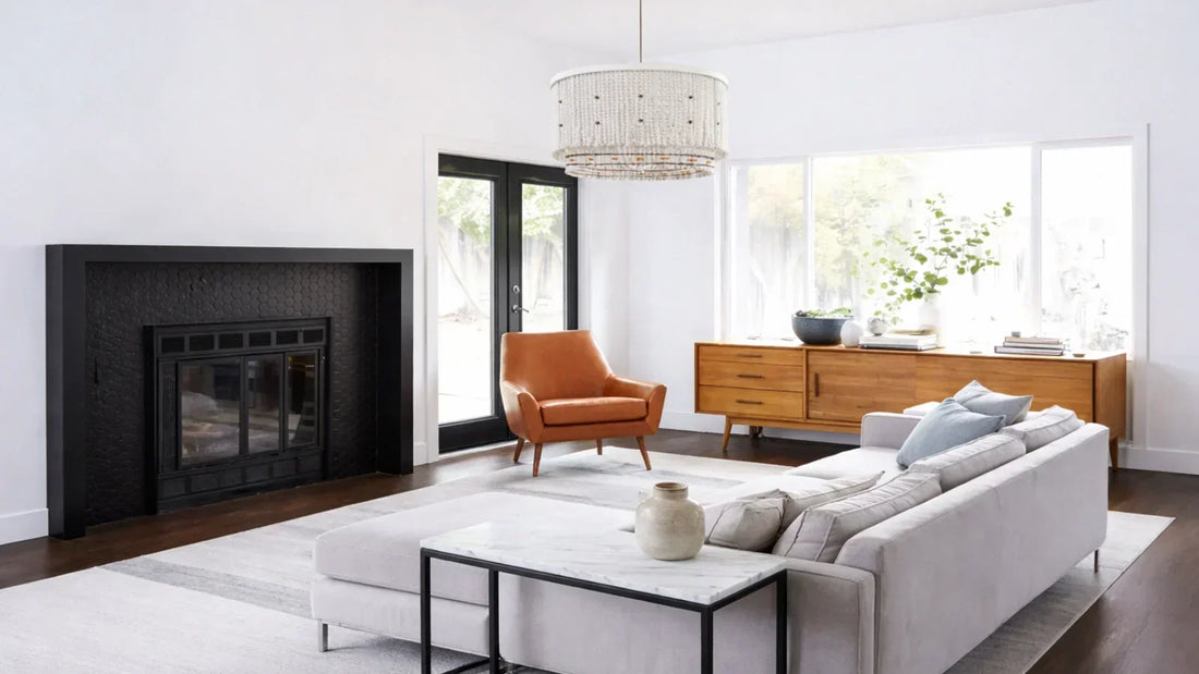 Scale and proportion in interior design illustrated by a living room with a low-profile sectional, large neutral rug, statement wood beads chandelier, and properly sized furniture layout.