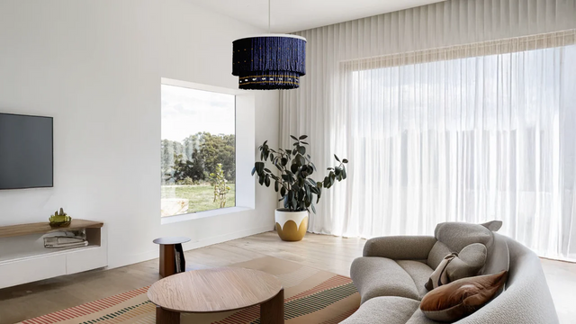 Bright, minimal living room with beaded pendant lighting and neutral rug, showcasing what to buy first in a new home.
