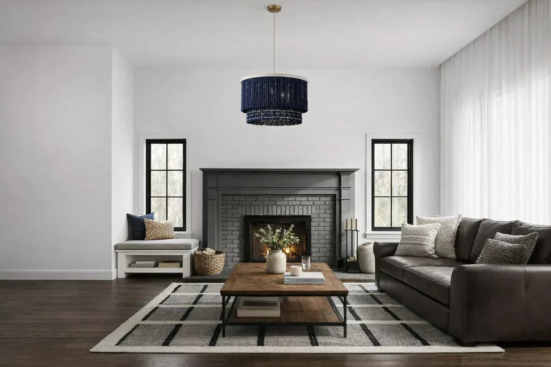 Modern living room with leather and dark wood furniture, black and white geometric rug, and a sculptural wood beads chandelier, illustrating the importance of lighting in interior design.